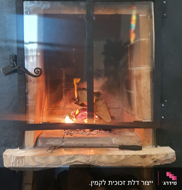 מסגרת מתכת שחורה סביב אח עם אש בוערת